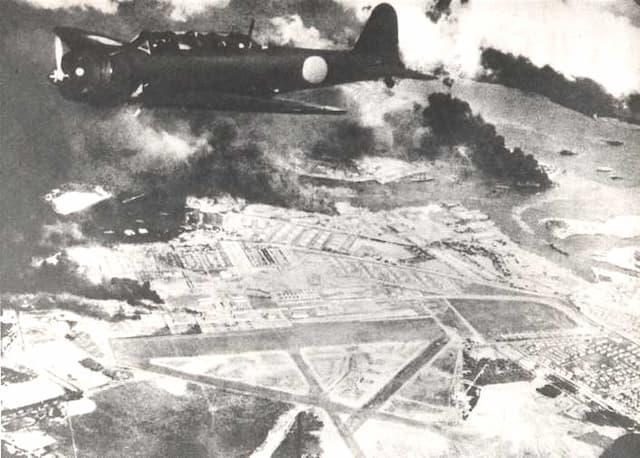 炎上する真珠湾と、その上空を飛行する日本海軍の九七式艦上攻撃機（出典：wikipedia）